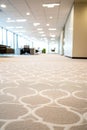 Modern office carpet flooring with geometric pattern leading to blurred workspace background Royalty Free Stock Photo