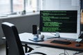 Modern Office Desk Featuring Smartphone and Baseball Beside Coding Monitor Royalty Free Stock Photo