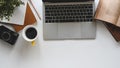 Modern office desk include laptop, camera, coffee cup, notebook, book, potted plant and pencil. Top view of office desk. Royalty Free Stock Photo