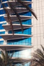 A modern office or hotel building with a mirrored blue facade surrounded by palm trees Royalty Free Stock Photo