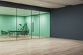 Modern office interior with blank dark wall and glass partition, wooden floor, and minimalistic furniture, concept of space for