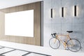 Modern office interior with a blank white poster on a wood and concrete wall, and a bicycle parked alongside. Royalty Free Stock Photo