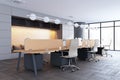 Modern office interior with desks, chairs, and computer monitors, large windows background, concept of workplace. Royalty Free Stock Photo