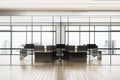 Modern office interior with glass partitions, city view through large windows, and empty workspaces on a wood-toned floor, concept Royalty Free Stock Photo