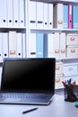 Modern office interior with laptop, chairs and bookcases