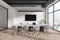 Modern office interior with a long meeting table, chairs, and city view through large windows. Light, contemporary business space Royalty Free Stock Photo