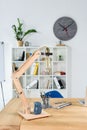 Modern office interior with wooden table, desklamp and stationery placed