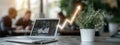 In a modern office, a laptop displays financial data with a rising graph. A small plant adds life to the workspace as