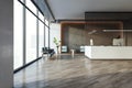 Modern office lobby interior with a reception desk, wooden elements, and furniture, large windows provide a bright background, Royalty Free Stock Photo