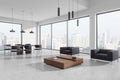 Modern office lounge area with large windows, minimalist furniture, and city skyline in the background, concept of contemporary Royalty Free Stock Photo