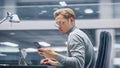 Modern Office: Portrait of Creative Businessman Sitting at His Desk, Working on Laptop, Using Smar Royalty Free Stock Photo