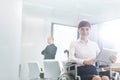 Portrait of smiling disabled businesswoman sitting with digital tablet in boardroom at office