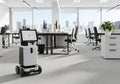 Modern office setting with a small, wheeled robot featuring a rectangular screen and camera. The Royalty Free Stock Photo