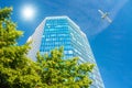 A modern office skyscraper and white passenger aircraft flying over this building Royalty Free Stock Photo