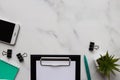 Modern office table desk with copy space. Workplace with notepad, clipboard with sheet of paper, pen, smartphone, and