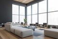 Modern office waiting area with grey armchairs and sofa  a marble coffee table  wooden parquet. Panoramic city view windows. Hotel Royalty Free Stock Photo
