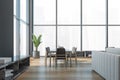 Modern office waiting area with grey armchairs and sofa, a marble coffee table, wooden parquet. Panoramic city view windows. Hotel Royalty Free Stock Photo