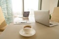 Modern office workplace, coffee cup, laptops on conference negotiating table Royalty Free Stock Photo