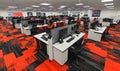 modern open plan office interior with multiple workstations and vibrant red and black patterned carpet flooring Royalty Free Stock Photo