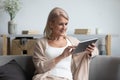 Elderly woman relax at home using electronic tablet Royalty Free Stock Photo