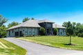 Modern one-story, luxurious, house with large windows and huge green lawn. Landscape on summer sunny day under blue cloudy sky Royalty Free Stock Photo