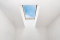 A modern open skylight mansard window in an attic room against blue sky. Royalty Free Stock Photo