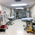 Modern operating room with various medical equipment, surgical tables, monitors and cabinets. The image is suitable for use in