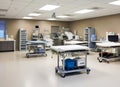 Modern operating room with various medical equipment, surgical tables, monitors and cabinets. The image is suitable for use in