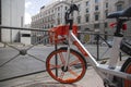 Modern orange bike for rent on the street of Madrid, Spain