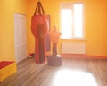 Modern orange boxing and karate room with sun on the window, gym, background, dummy