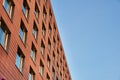 Modern orange bricked facade with windows against the sky is an example of building neat architecture. Modern orange exterior Royalty Free Stock Photo