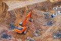 modern orange excavator digs the ground under the foundation pit at construction site Royalty Free Stock Photo