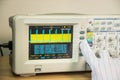 Modern oscilloscope, man`s hand adjusting wave signals, closeup