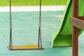 A modern outdoor playground in the courtyard of a building. Colorful children\'s swings and slides for recreation and games Royalty Free Stock Photo