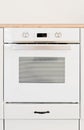 modern oven built in kitchen furniture, front view, vertical. White cooker with heat control buttons.