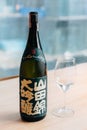 Modern packaging Japanese Sake with glass wine on wooden table. For Japanese food fine dining