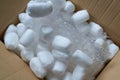 Modern packaging materials are bubble wrap and pieces of foam filling in an open cardboard box Royalty Free Stock Photo