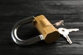 Modern padlock with keys on black wooden table, closeup Royalty Free Stock Photo