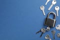 Modern padlock with keys on blue background, flat lay. Space for text Royalty Free Stock Photo