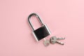 Modern padlock with keys on pink background, top view