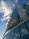 Modern palace architecture, reflective windows, glass palace. Sky mirrored in the windows of a building. Clouds in the sky, corner Royalty Free Stock Photo