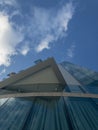 Modern palace architecture, reflective windows, glass palace. Sky mirrored in the windows of a building. Clouds in the sky, corner Royalty Free Stock Photo