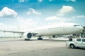 Modern passenger or big cargo airplane parking at terminal gate of international airport on a cloudy blue sky background Royalty Free Stock Photo