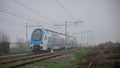 Modern passenger double decker train rushing through foggy weath Royalty Free Stock Photo