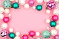 Pastel Christmas bauble frame over a pink background