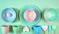 Modern pastel pink, green and blue ceramic tableware on pale green. Royalty Free Stock Photo