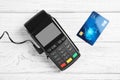 Modern payment terminal and credit card on white wooden background Royalty Free Stock Photo
