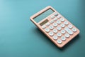 modern peach colour pastel calculator and white button on green background, finance accounting concept Royalty Free Stock Photo