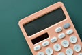 modern peach colour pastel calculator and white button on green background, finance accounting concept Royalty Free Stock Photo