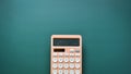 modern peach colour pastel calculator and white button on green background, finance accounting concept Royalty Free Stock Photo